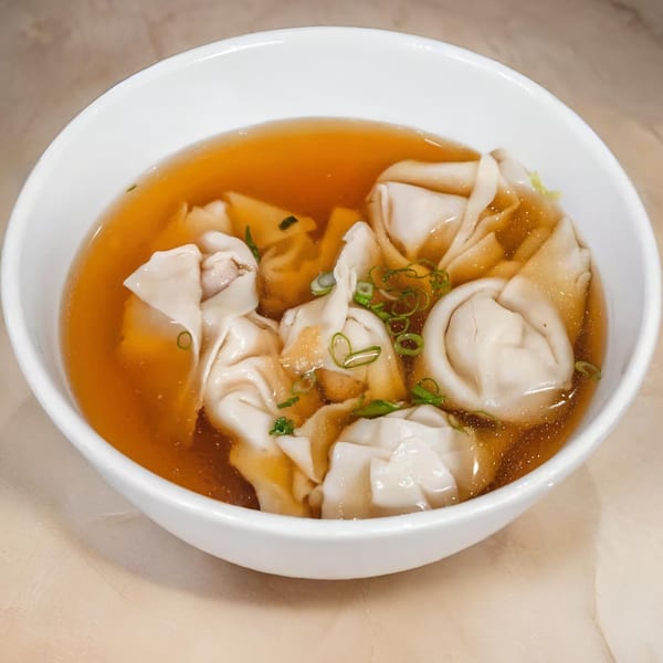 A white bowl of Great Wall Restaurant's wonton soup with broth and green onions.